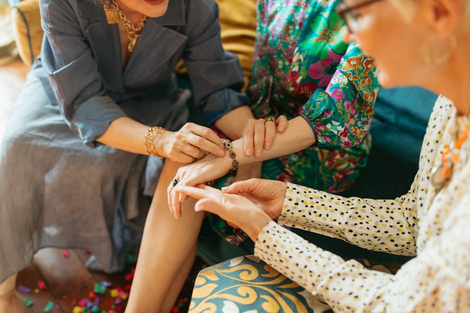 A group of friends at a permanent jewelry pop-up event, one getting a bracelet welded while others watch