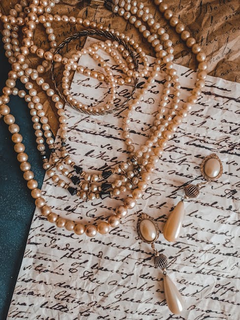 A strand of cultured pearls showing varying degrees of yellowing, from cream-white to noticeably amber
