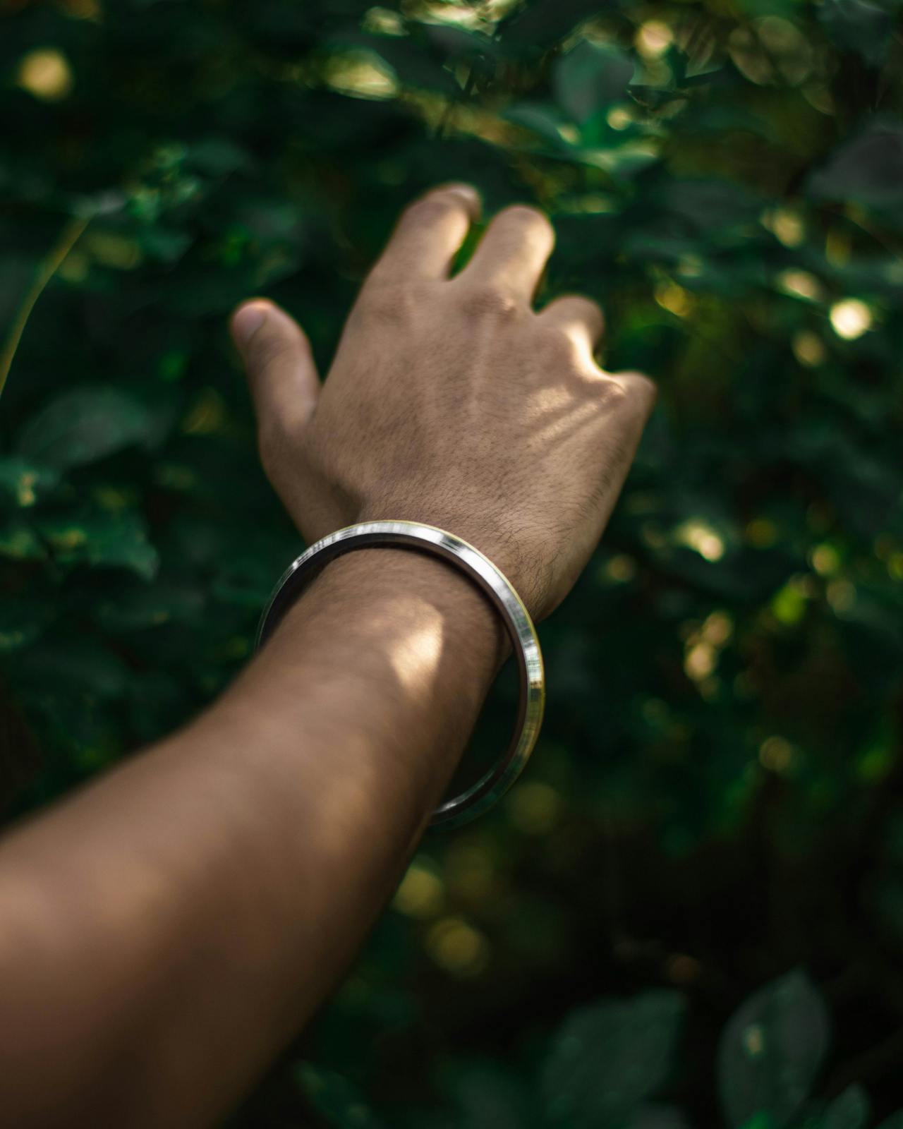 comparison of a bangle sliding over a hand versus a cuff bracelet being slipped on from the side