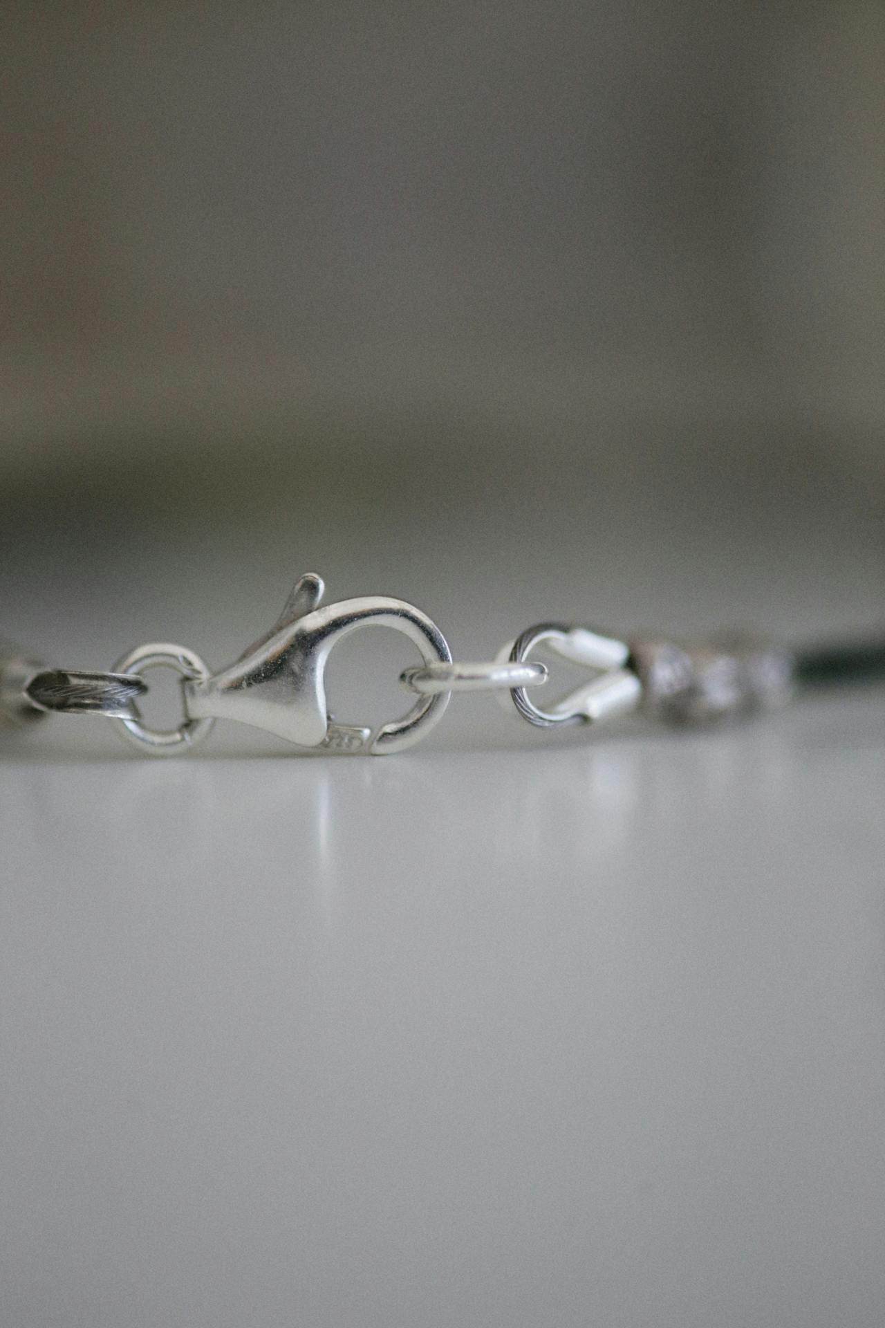 close-up of an open cuff gap showing how it slides onto the wrist, next to a hinged cuff with its clasp mechanism visible