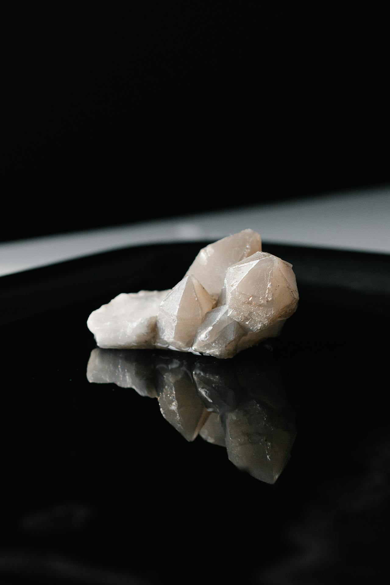 a cluster of aura quartz crystals on a dark background showing iridescent rainbow flashes on the surface