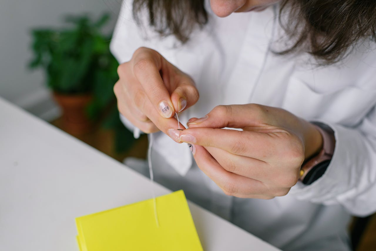 step by step photos showing a necklace being threaded through a plastic straw and clasped at the end