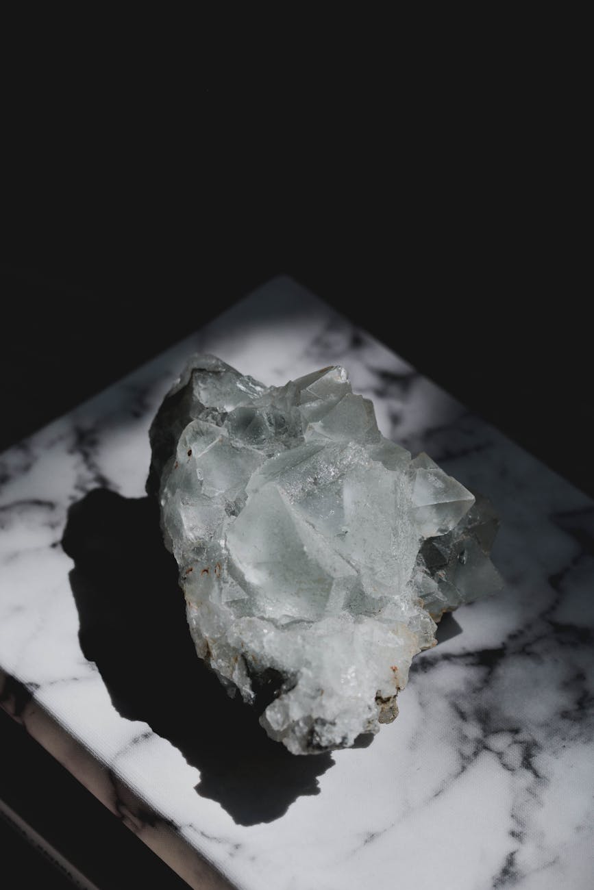 close-up of a natural apophyllite crystal cluster showing pale green pyramid-shaped formations on dark basalt matrix